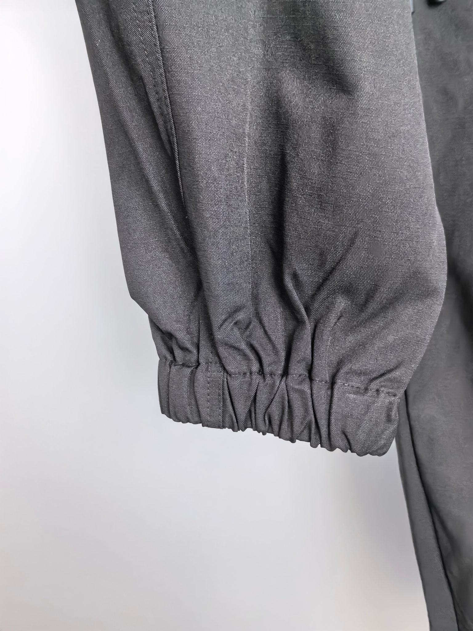 Dark cuffed cargo pants with gathered elastic hem at ankle.