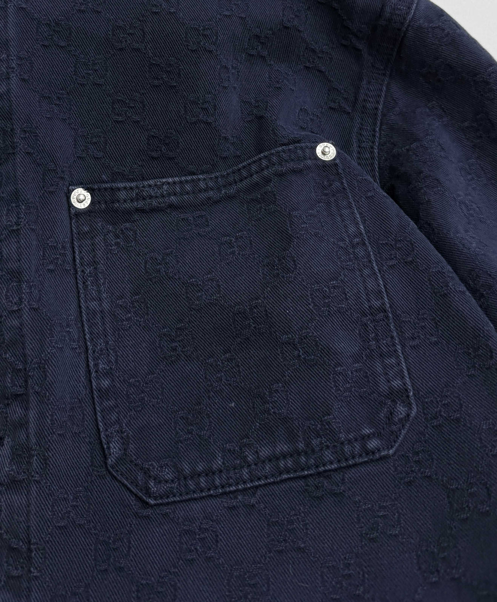 Gucci denim jacket chest pocket with snap buttons on dark navy fabric