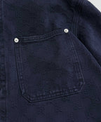 Gucci denim jacket chest pocket with snap buttons on dark navy fabric
