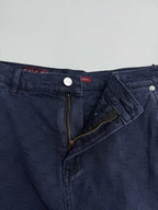 Navy Gucci pants waistband close-up, front zip fly and GG logo fabric pattern