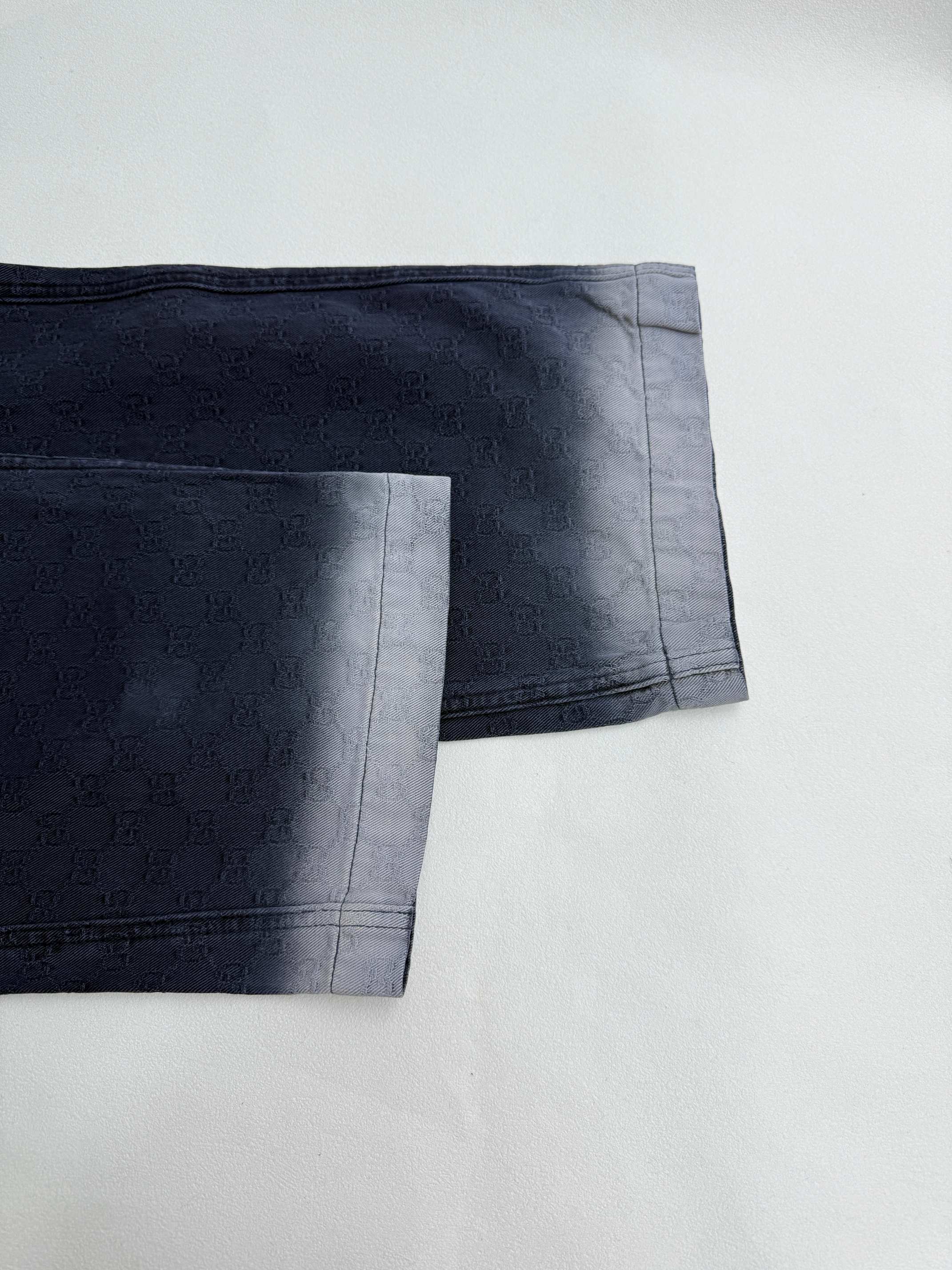 Navy Gucci pants hem close-up, side seam and cuff finish on GG-pattern fabric