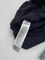 Gucci pants care label on dark GG-patterned fabric, folded waistband area