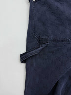Navy Gucci pants side view close-up, angled seam and cuffed hem, GG pattern