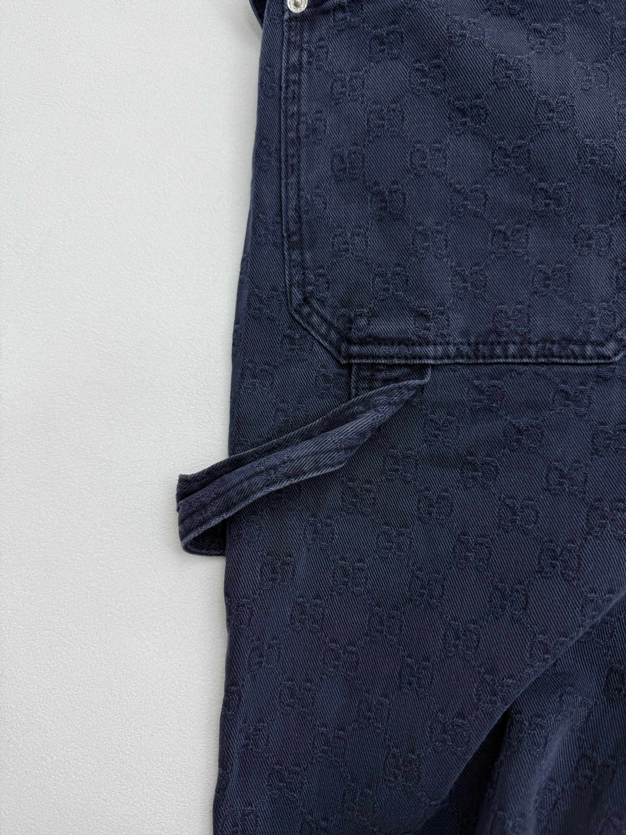 Navy Gucci pants side view close-up, angled seam and cuffed hem, GG pattern