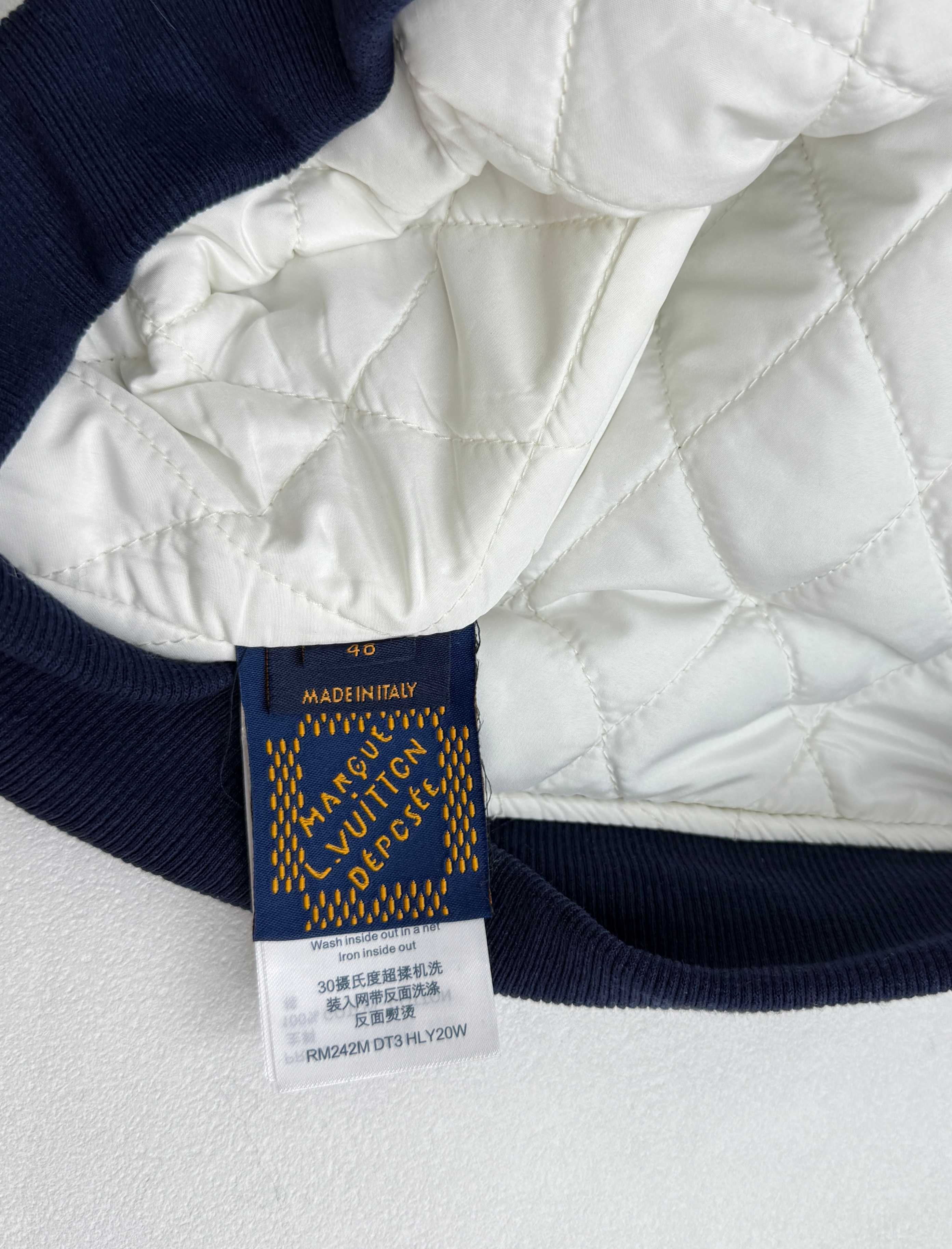 Louis Vuitton garment label on navy ribbed hem with care and size text
