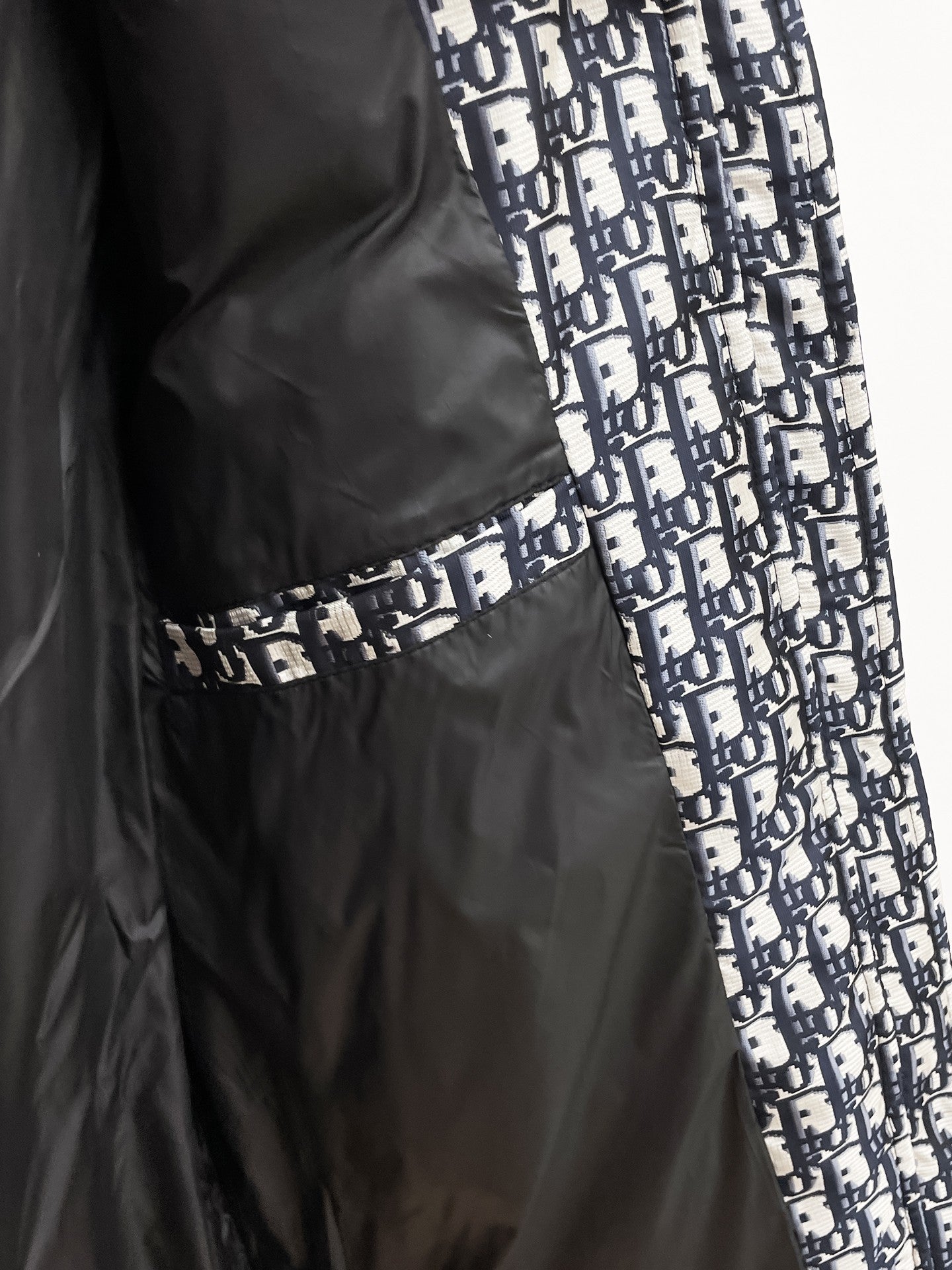 Long black Dior garment with blue-and-white logo panel