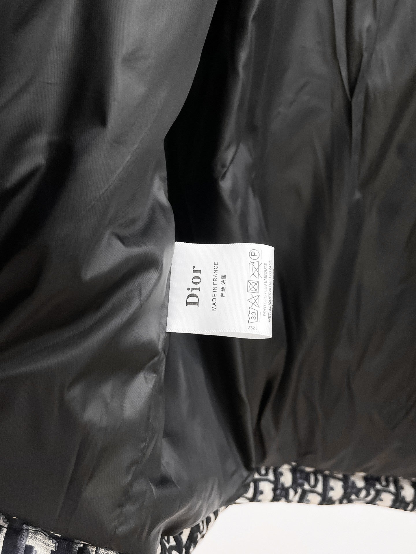 Long black Dior garment with white Dior care label