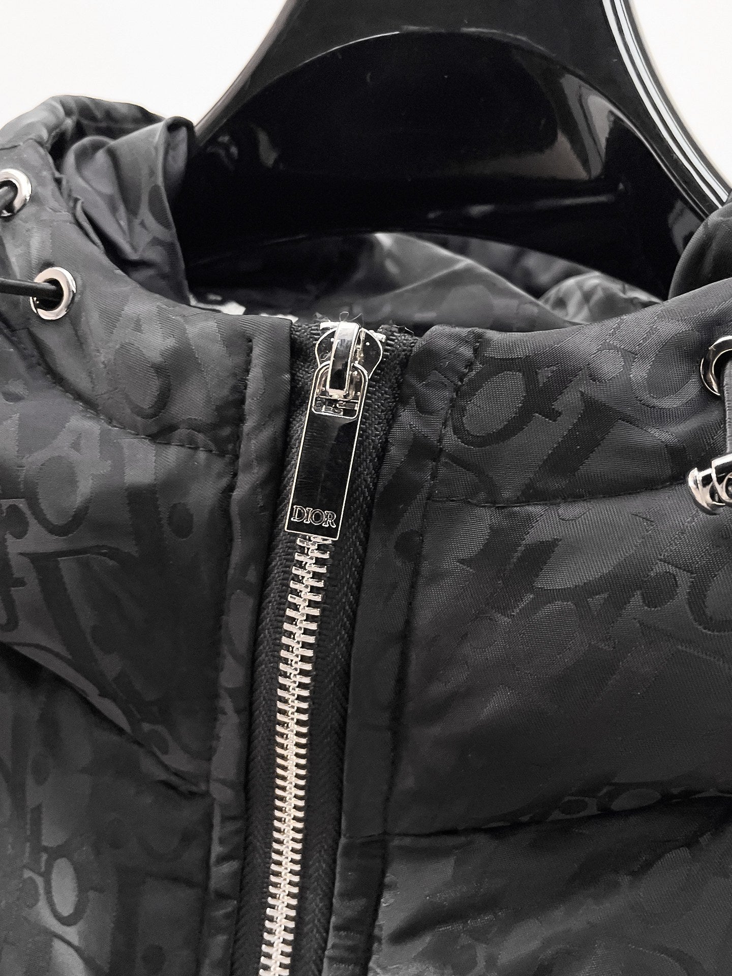 Dior hooded puffer jacket close-up, black zipper and logo-print hood detail