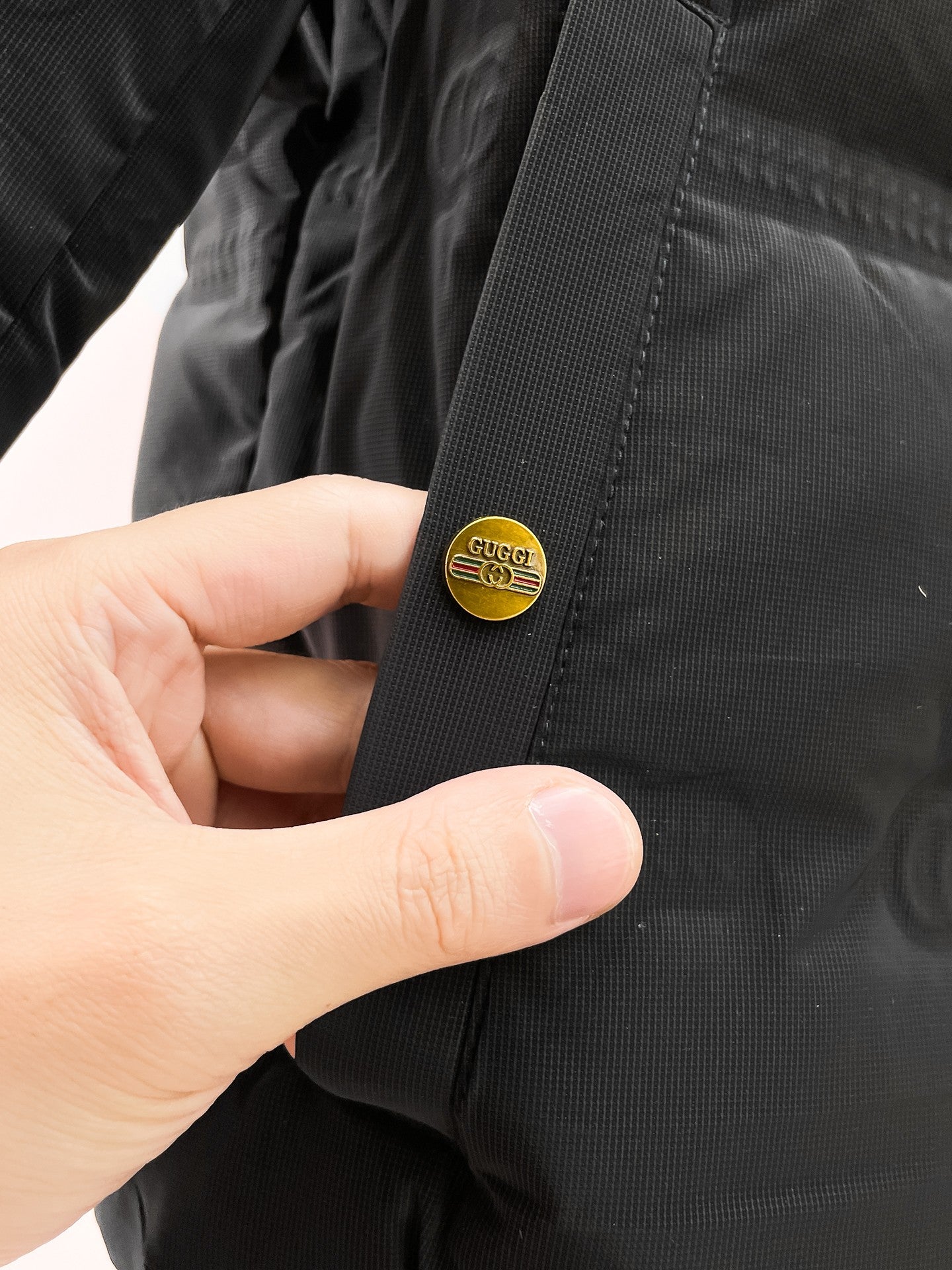 Long puffer jacket sleeve cuff with small round logo patch
