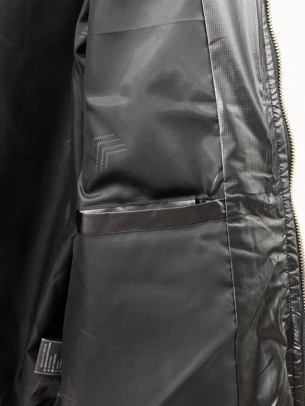 Black puffer jacket close-up of pocket and inner lining near zipper
