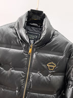Black puffer jacket close-up of gold zipper, stand collar, and chest patch