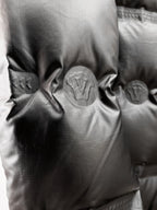 Black quilted puffer jacket fabric close-up with circular quilt stitching detail