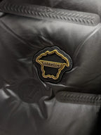 Black puffer jacket close-up of embroidered Versace logo patch