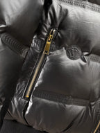 Black puffer jacket close-up of gold zipper and quilted front panel