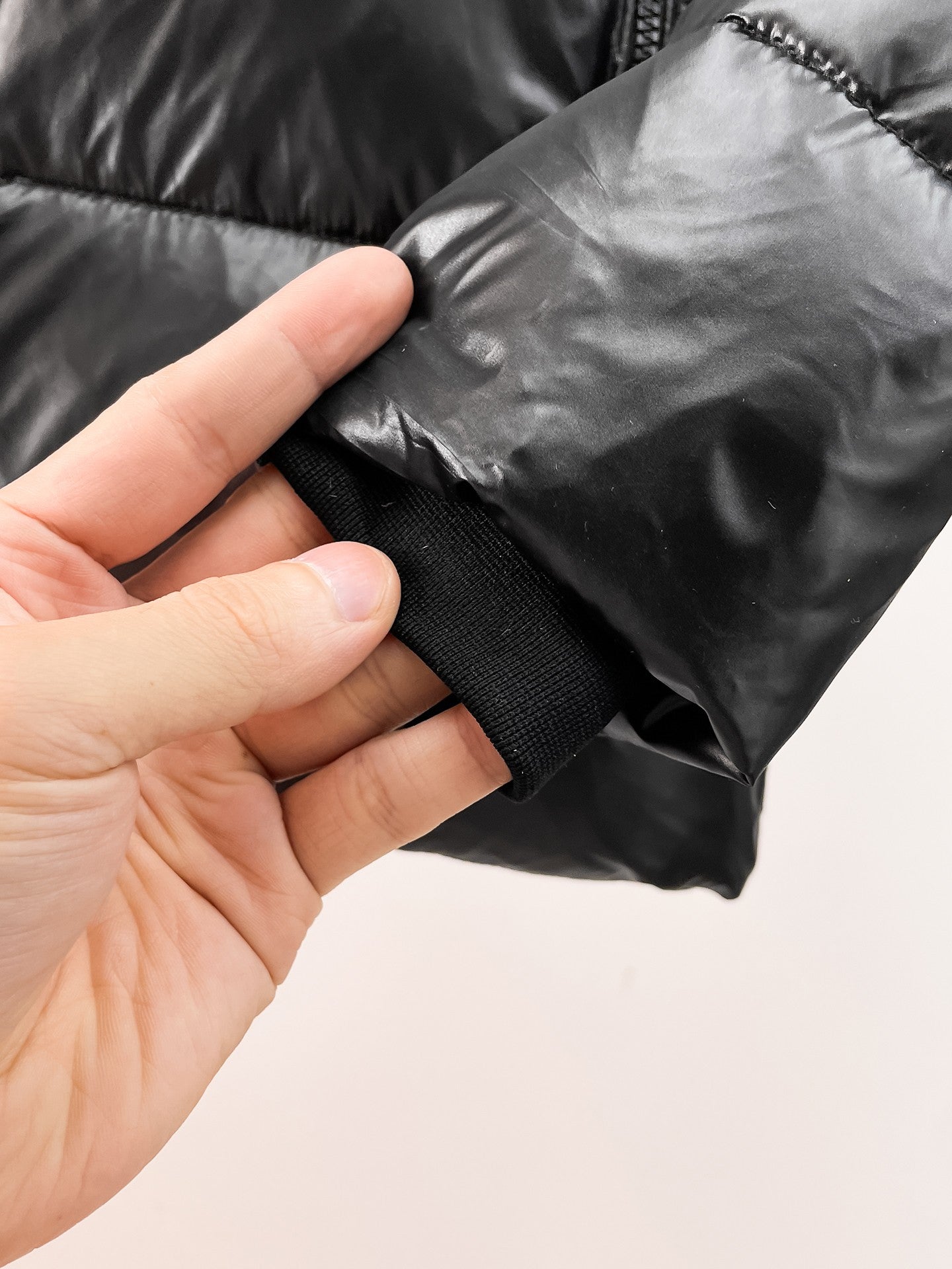 Burberry long puffer jacket, dark shiny black, cuff area with elastic trim.
