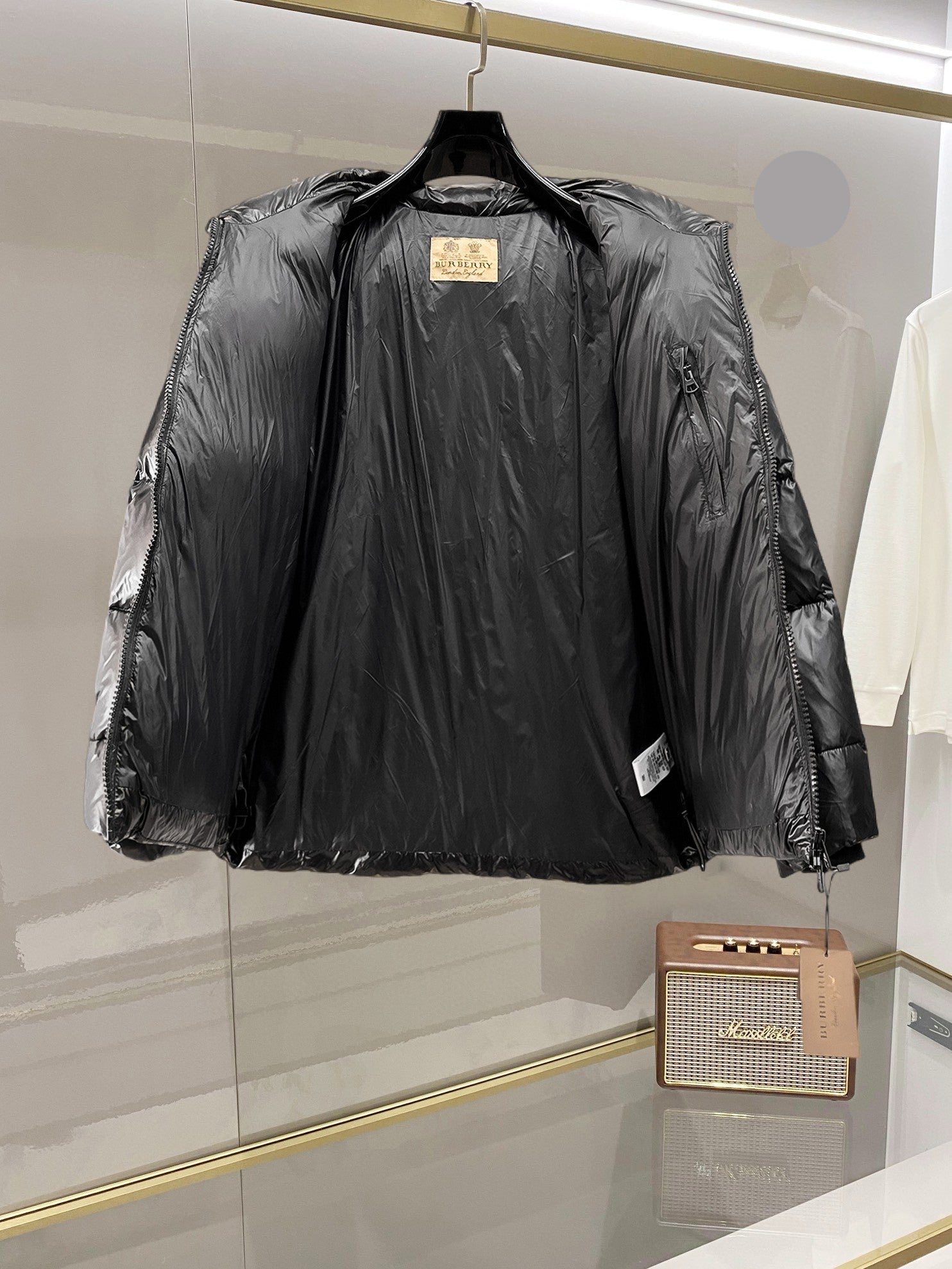 Burberry long puffer jacket, dark shiny black, front view with center zip and high collar.