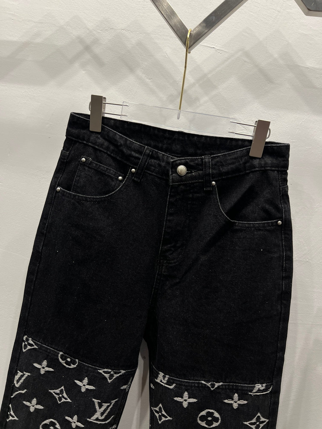 Black denim pants with monogram logo trim along the lower leg