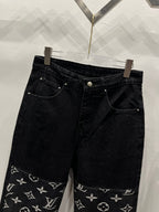 Black denim pants with monogram logo trim along the lower leg