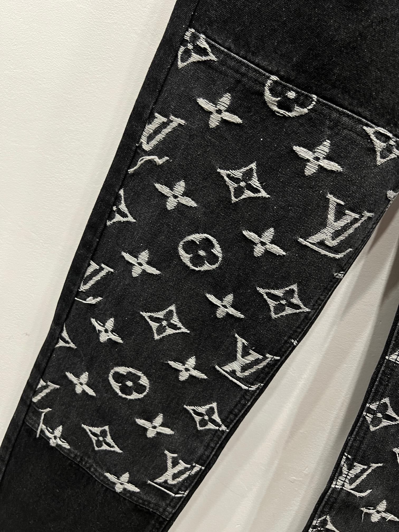 Black denim pants close-up of monogram logo print on the inner hem