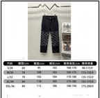 Black denim pants with monogram logo panels on the legs