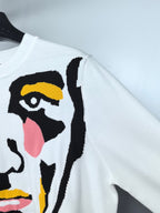 White long-sleeve sweater with multicolor face graphic detail on sleeve