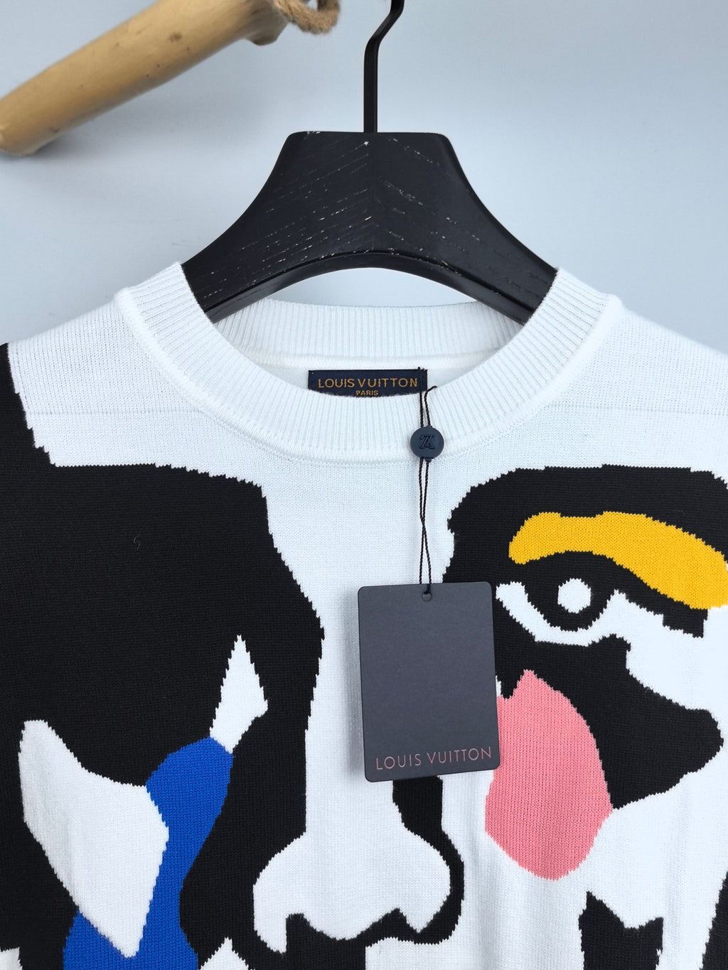 White crewneck sweater with Louis Vuitton neck label and partial multicolor face graphic