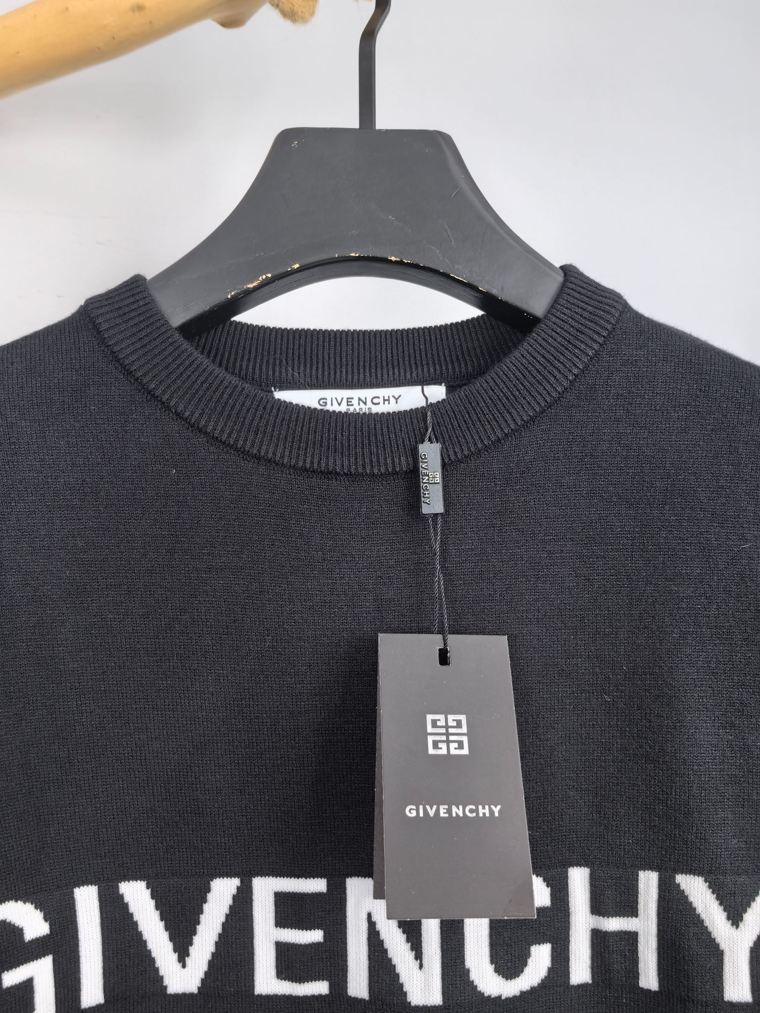 Dark crewneck sweatshirt collar with zip tag and Givenchy logo label