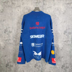 Blue long-sleeve sweater with back logo text and emblem patches