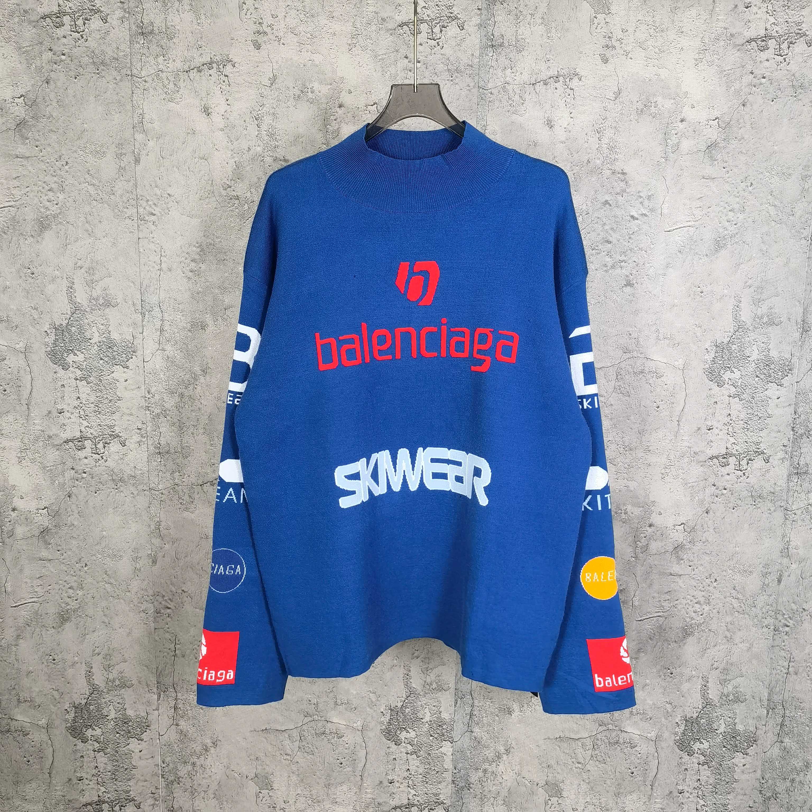 Blue long-sleeve sweater with red and white logo graphics and ribbed crew neck