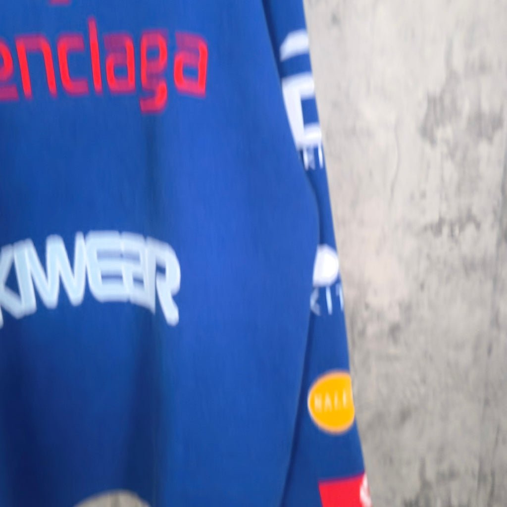 Blue long-sleeve shirt with large 'SKWER' logo and graphic print on sleeve