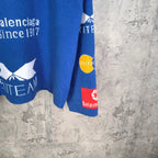 Blue long-sleeve shirt sleeve with 'KITÉ' text and Balenciaga logo print