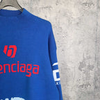 Blue sweater sleeve with white stripe cuff and red balenciaga logo print