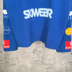 Blue long-sleeve shirt front hem with 'SKWER' logo and graphic sleeve prints