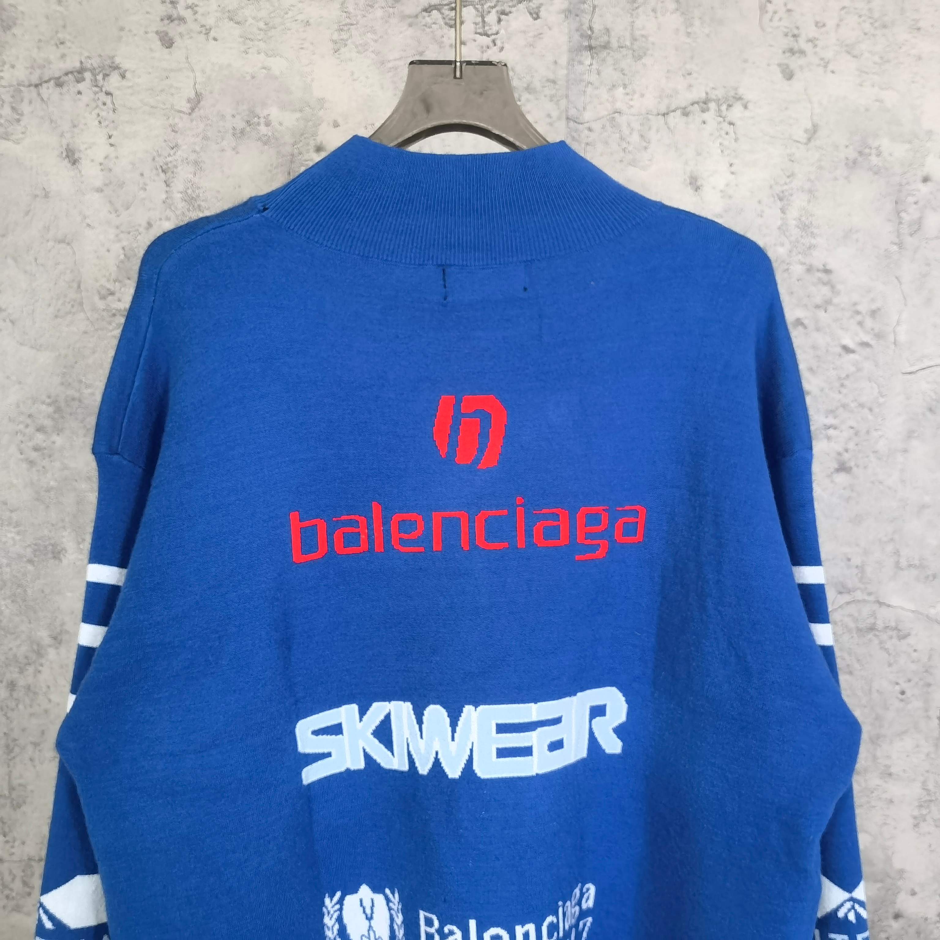 Blue sweater back view with red balenciaga logo and white SKWEAR text