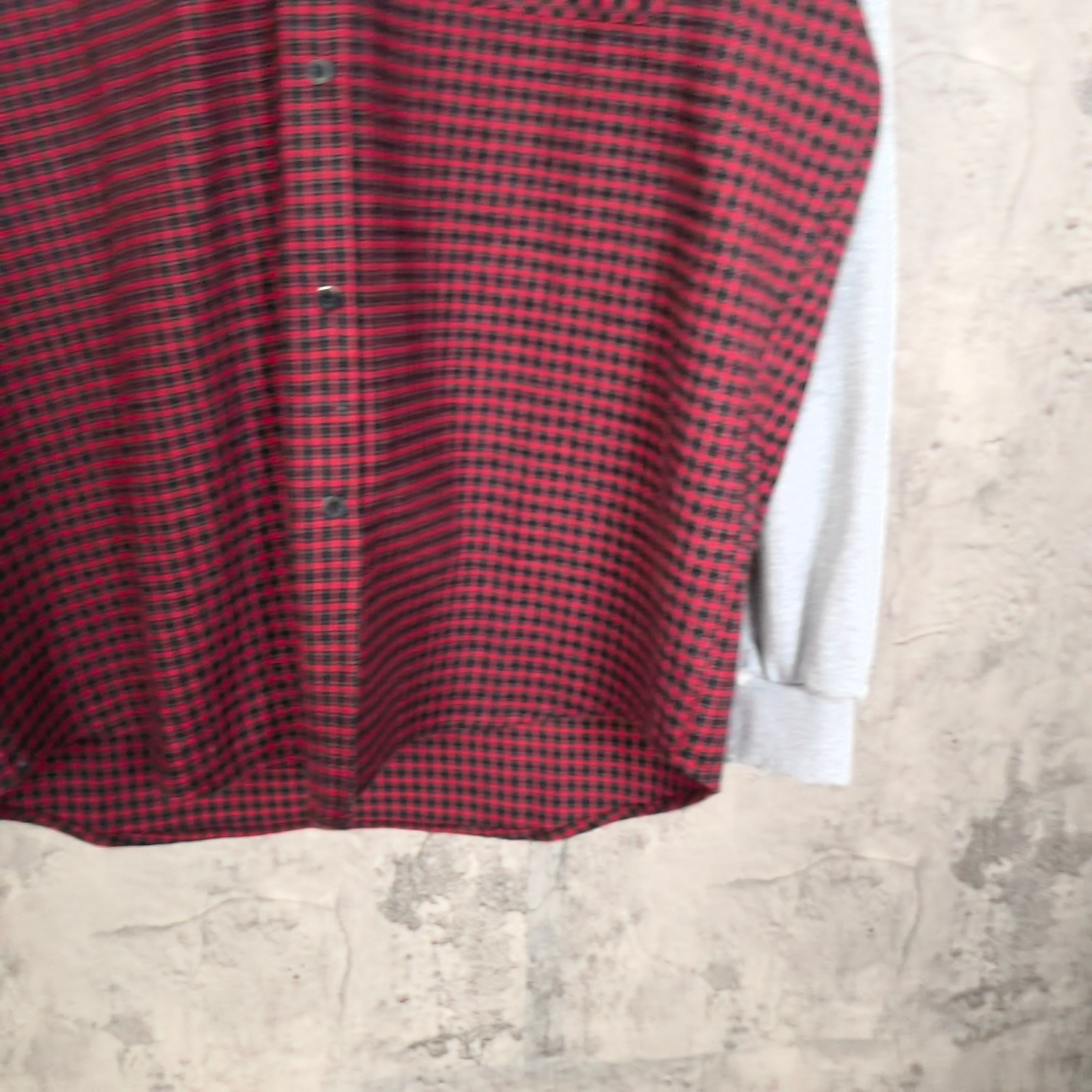 Red and black plaid long-sleeve top with central front seam and light gray cuffs