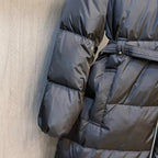 Black puffer coat sleeve and torso quilting with belt detail