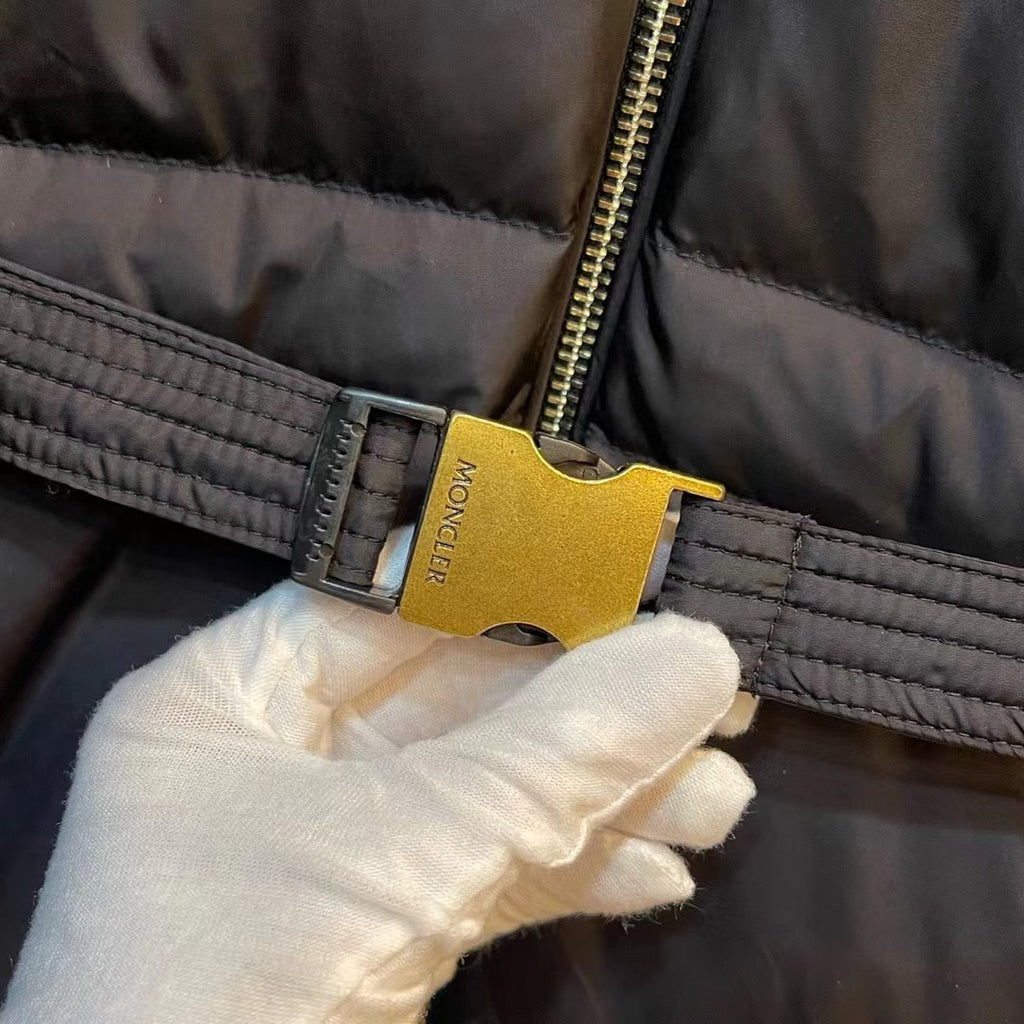 Front zipper pull and Moncler logo tag on black puffer coat