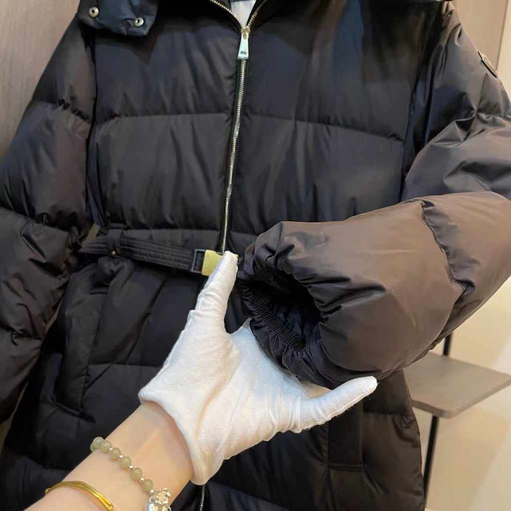 Black puffer coat close-up of belt buckle and glossy sleeve