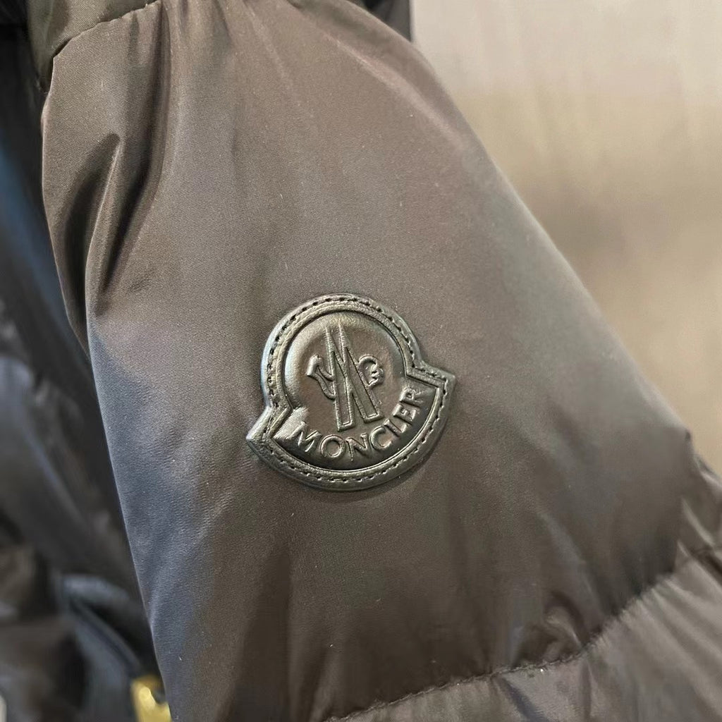 Moncler circular logo patch on dark puffer sleeve