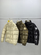 Three Moncler puffer jackets: light, olive, and black on hangers