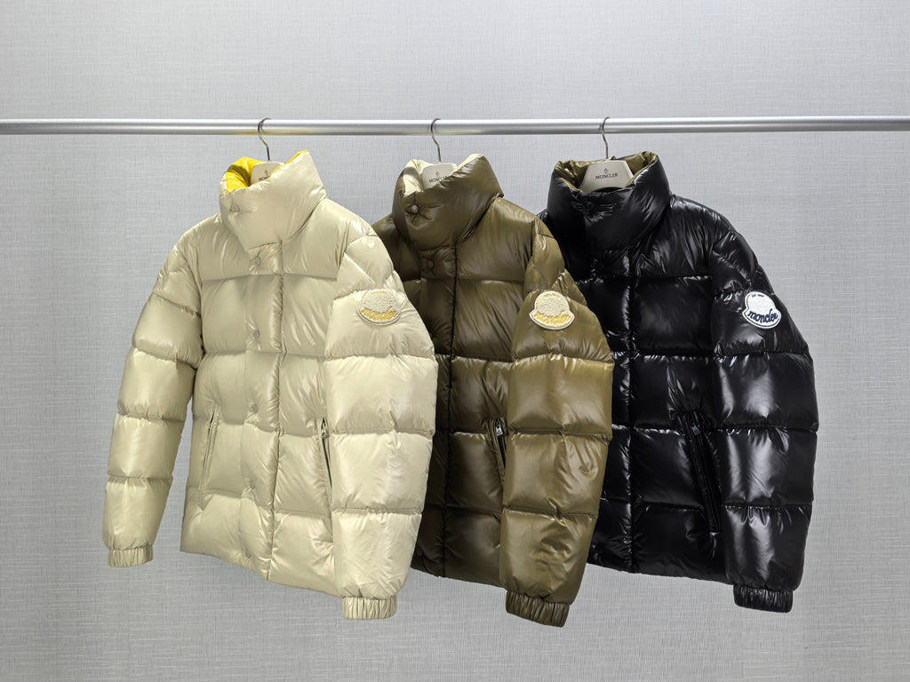 Three Moncler puffer jackets on hangers: light, olive, and black, front view