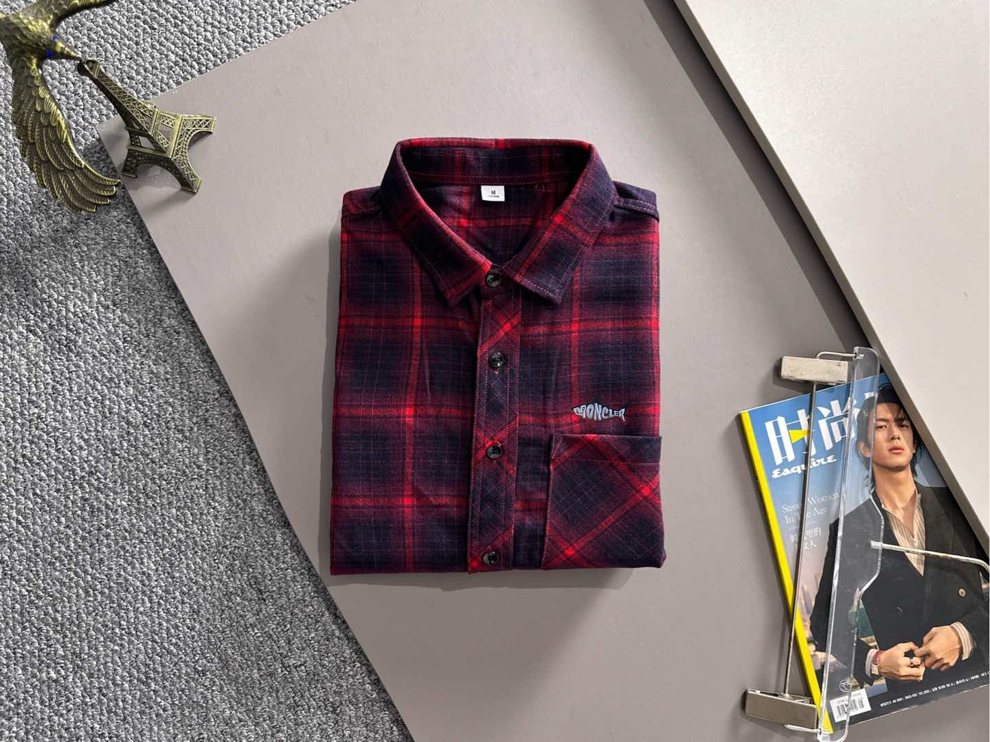 Long-sleeve plaid shirt on display, red and dark blue, button front and logo