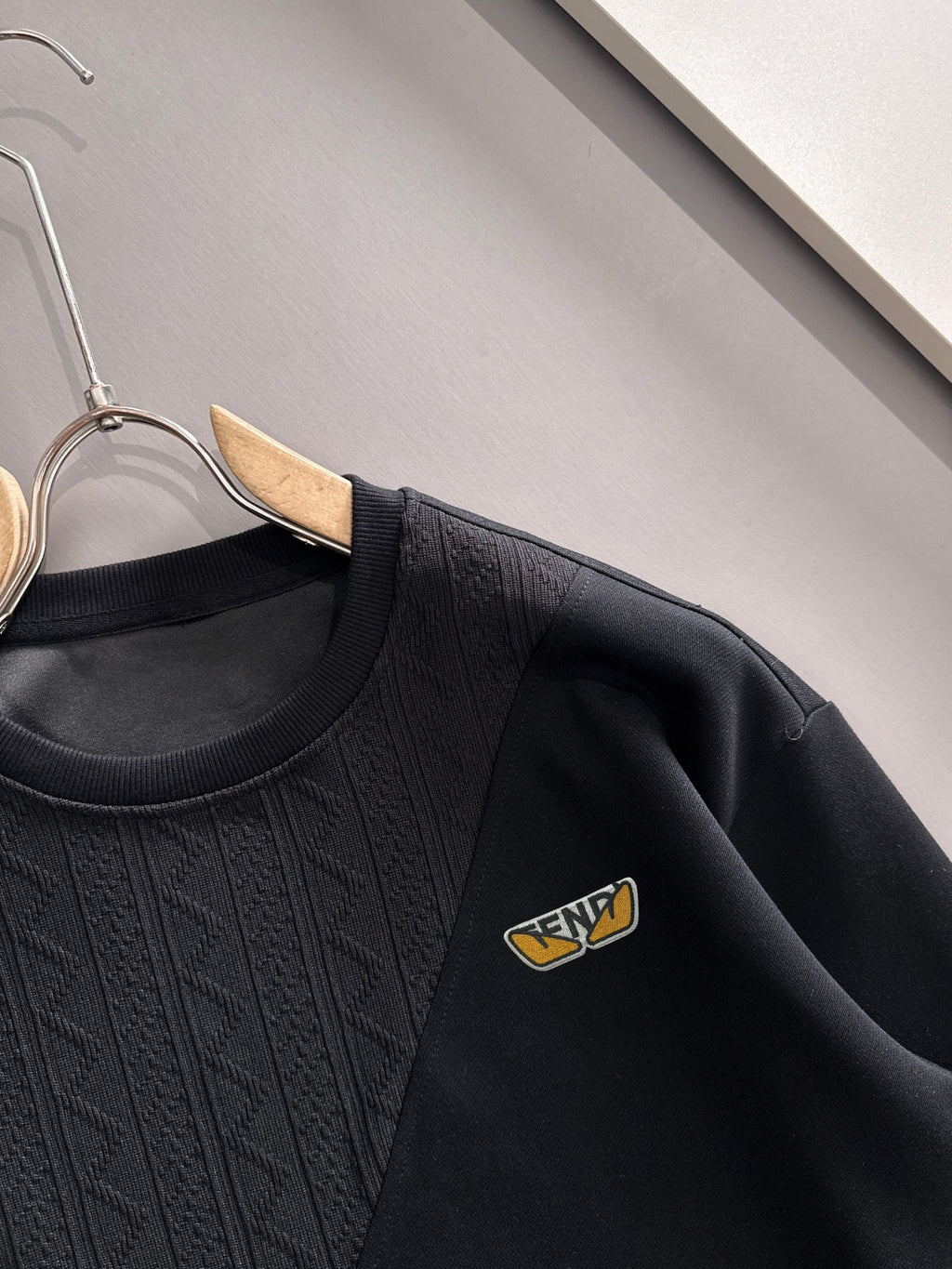 Fendi black long-sleeve sweatshirt close-up showing crew neck and logo patch