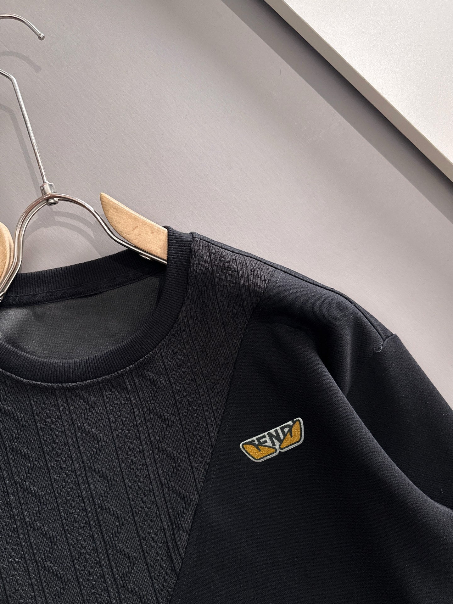 Fendi black long-sleeve sweatshirt close-up showing crew neck and logo patch