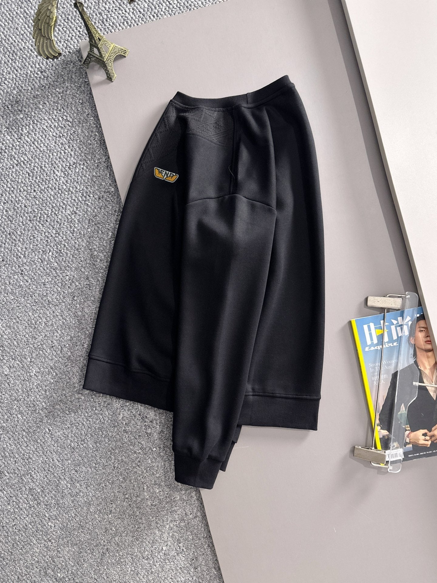 Fendi black long-sleeve sweatshirt with matching pants, both hanging on display