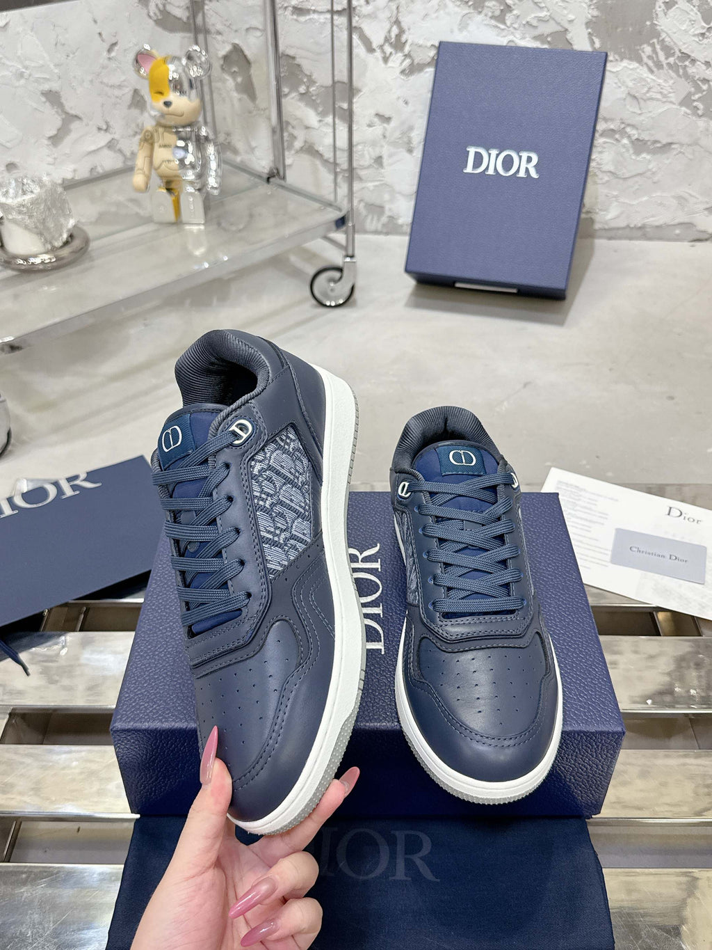 Unisex low-top sneakers in dark blue with laces and white midsoles on a blue box