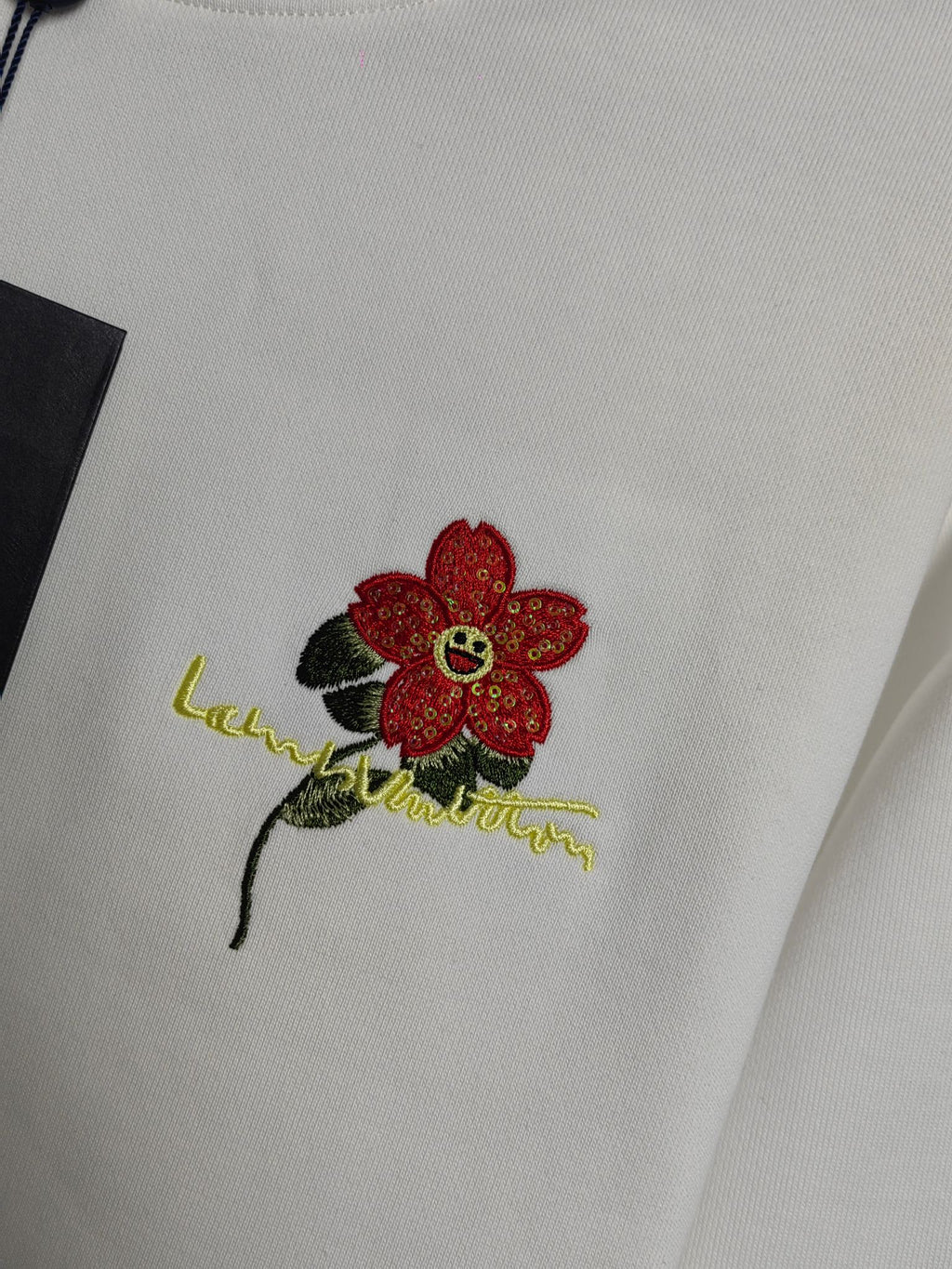 White sweatshirt with red flower embroidery and green outline detail