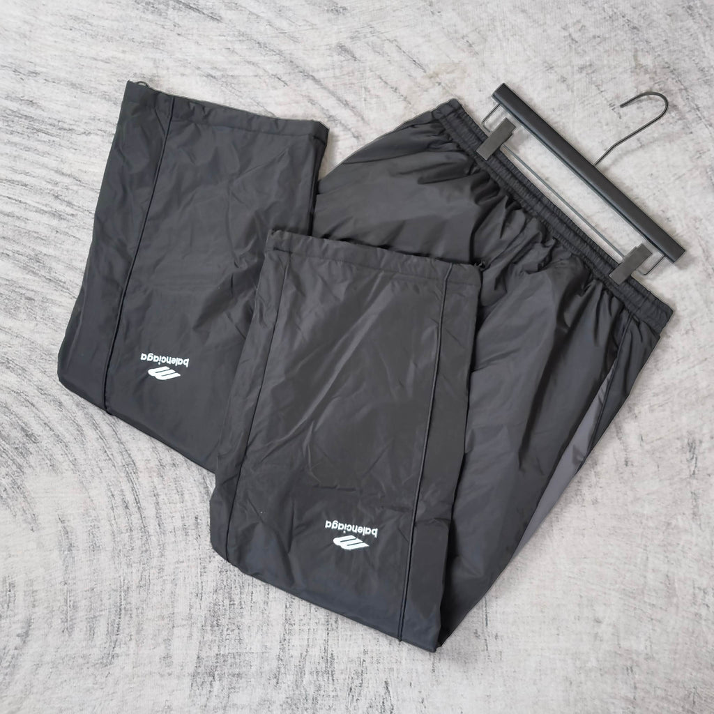 Black pants on hangers with elastic waistband and Balenciaga logo prints