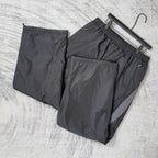 Black pants set on hangers with elastic waistband and visible front logo