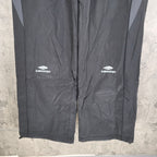 Dark gray Balenciaga logo track pants, side branding and straight legs